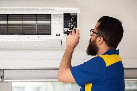 Air conditioning repair technician working on an outdoor unit